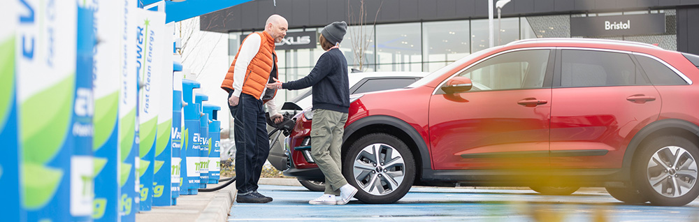 A couple charging their EV in a hub