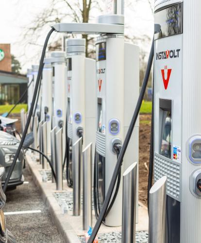 row of InstaVolt charge points with cars plugged in to charge