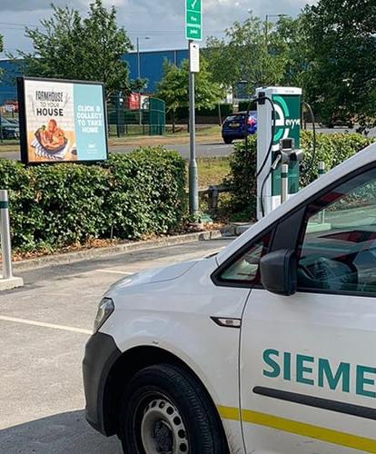 Siemens branded van parked in front of an Evyve charge point