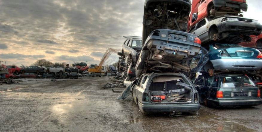 Scrapped cars piled on top of each other in scrap yard