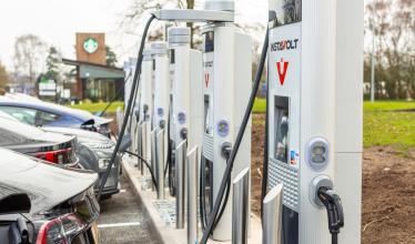 row of InstaVolt charge points with cars plugged in to charge