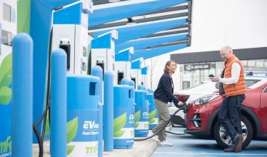 Couple charges their EV at MFG charger hub